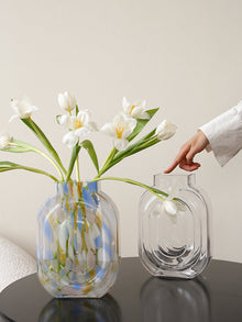 Clear glass vase shaped like a perfume bottle for decorative flower display