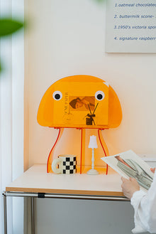 Jellyfish-inspired acrylic bookshelf with orange head and legs