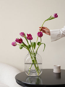 Clear glass vase shaped like a perfume bottle for decorative flower display