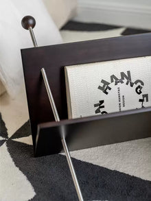 V-shaped cherry wood magazine rack with stainless steel detail