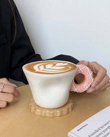 Ceramic mug with a playful donut-shaped handle