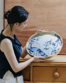 Peacock mirror decorative tray with floral motif and gold-toned wavy frame