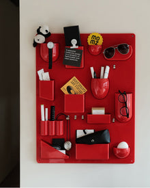 Red wall-mounted pocket organizer panel with compartments and hooks