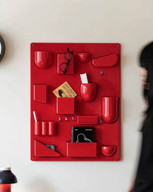 Red wall-mounted pocket organizer panel with compartments and hooks