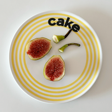 Striped ceramic dessert plate with colourful concentric lines and playful cake typography