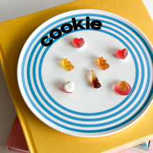 Striped ceramic dessert plate with colourful concentric lines and playful cake typography
