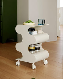 Modern green curved rolling side cart with open shelving and matching green wheels