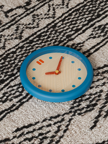 Vintage-style round blue wall clock with clean dial and pendulum