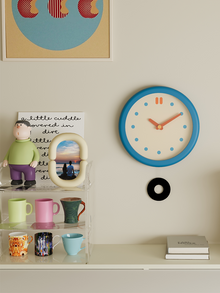 Vintage-style round blue wall clock with clean dial and pendulum