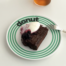 Striped ceramic dessert plate with colourful concentric lines and playful cake typography