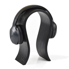 White wooden headphone stand for storing over-ear headphones on a desk