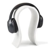 White wooden headphone stand for storing over-ear headphones on a desk