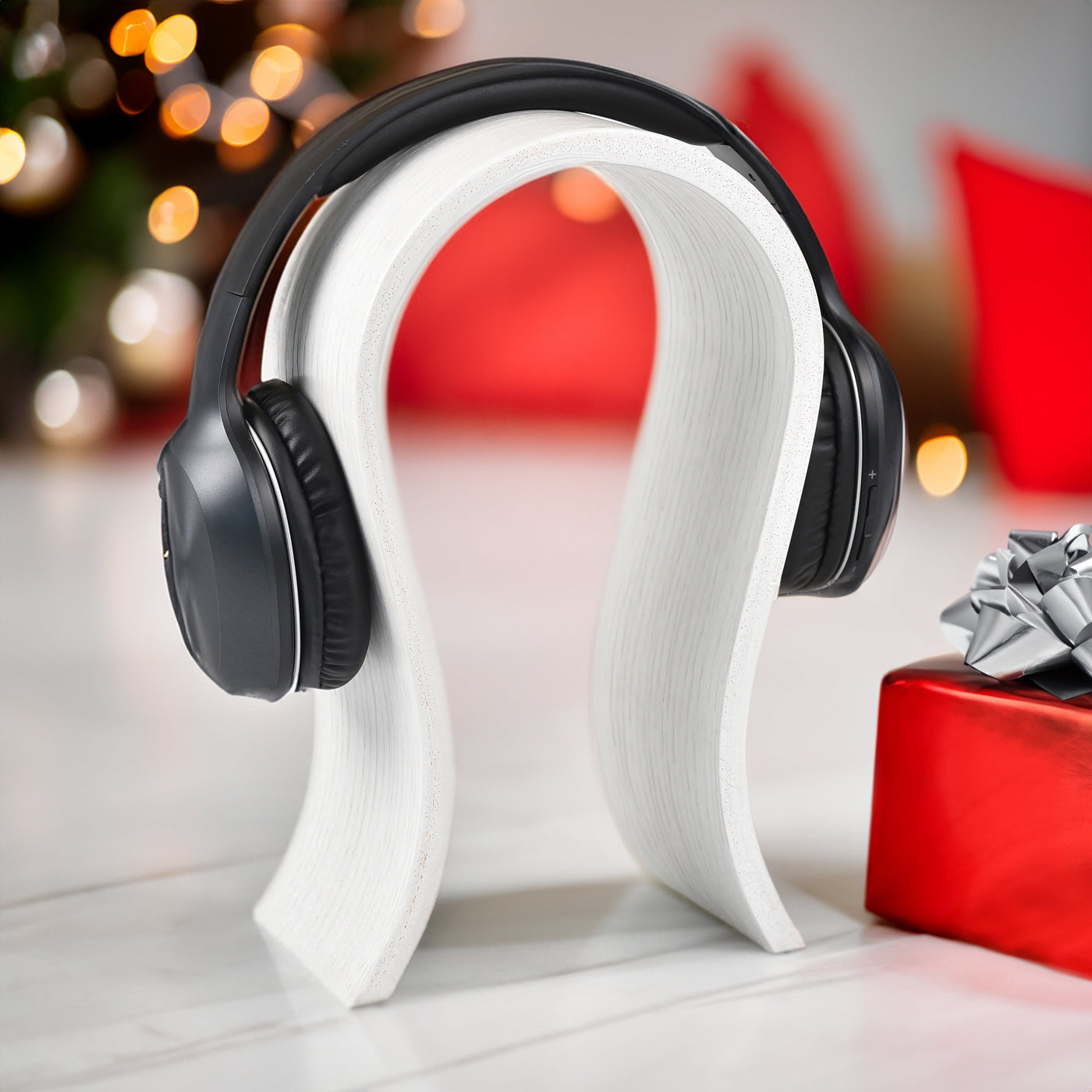 White wooden headphone stand for storing over-ear headphones on a desk
