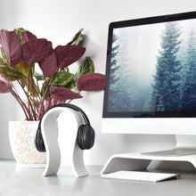 White wooden headphone stand for storing over-ear headphones on a desk