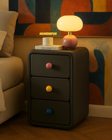 Narrow bedside cabinet with playful drawer knobs and compact storage