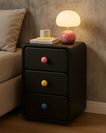 Narrow bedside cabinet with playful drawer knobs and compact storage