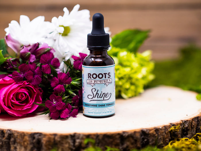 Bottle of Shine herbal infused hair oil for adding moisture and shine to hair ends