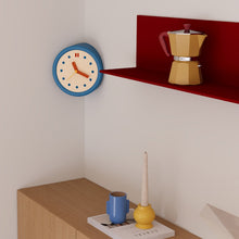 Blue corner wall clock with minimalist dot dial for a 90-degree wall edge
