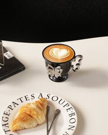 Beige ceramic mug with raised butterfly detail and butterfly-shaped handle