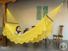 Yellow Estelí Deluxe L-bar cotton hammock with wooden spreader bars and decorative fringe