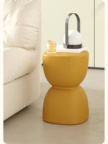 Yellow striped plastic stool and plant stand for home decor