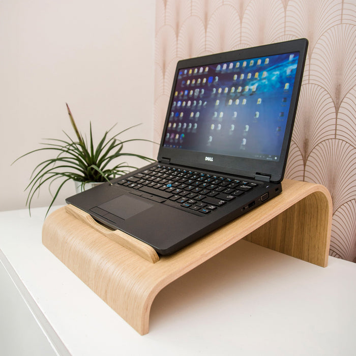 Oak wooden laptop stand with ventilation cutouts for a desk workspace