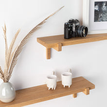 Set of two natural oak floating wall shelves with holders for home or office display